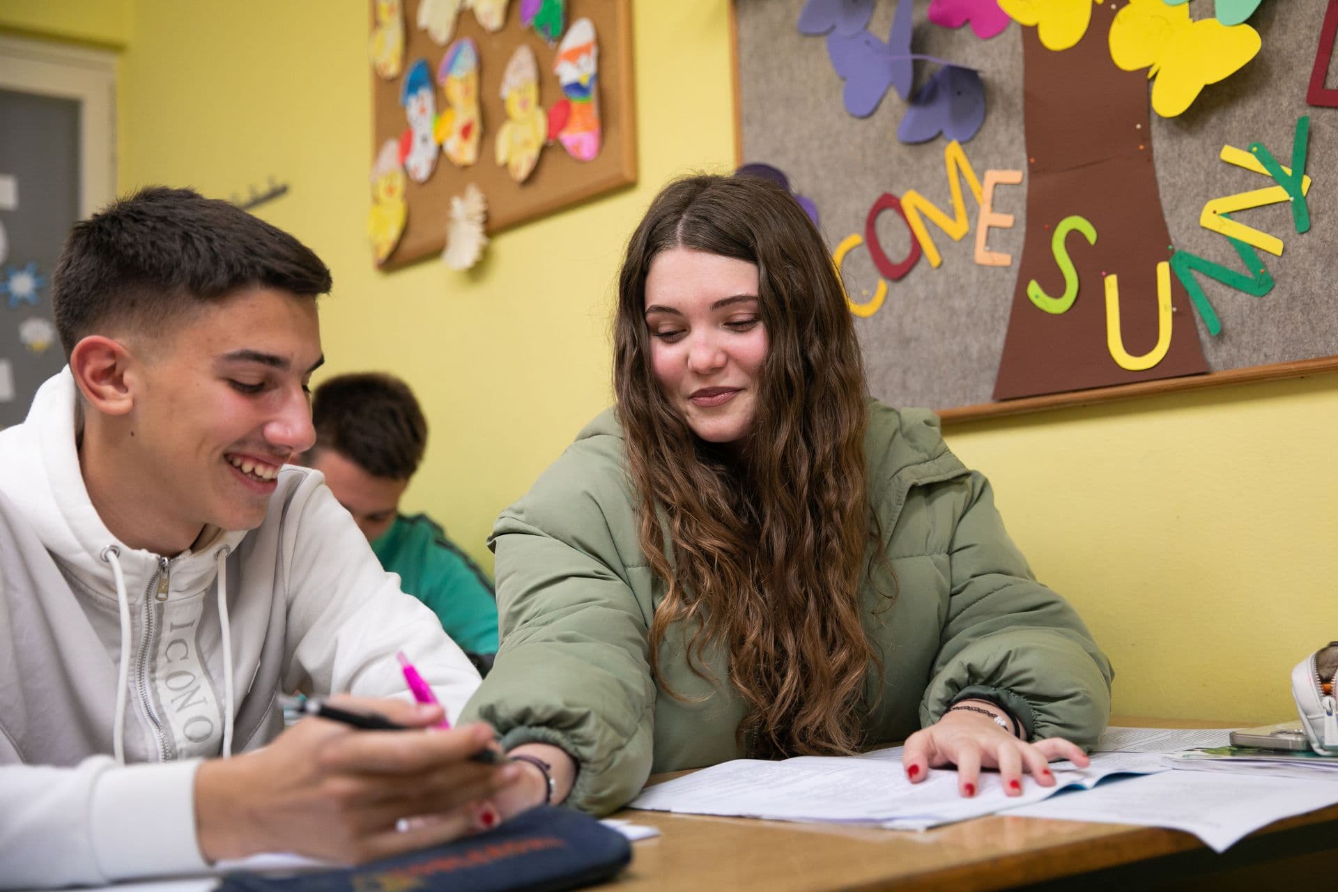 Secondary school students laughing at their desk during a lesson
