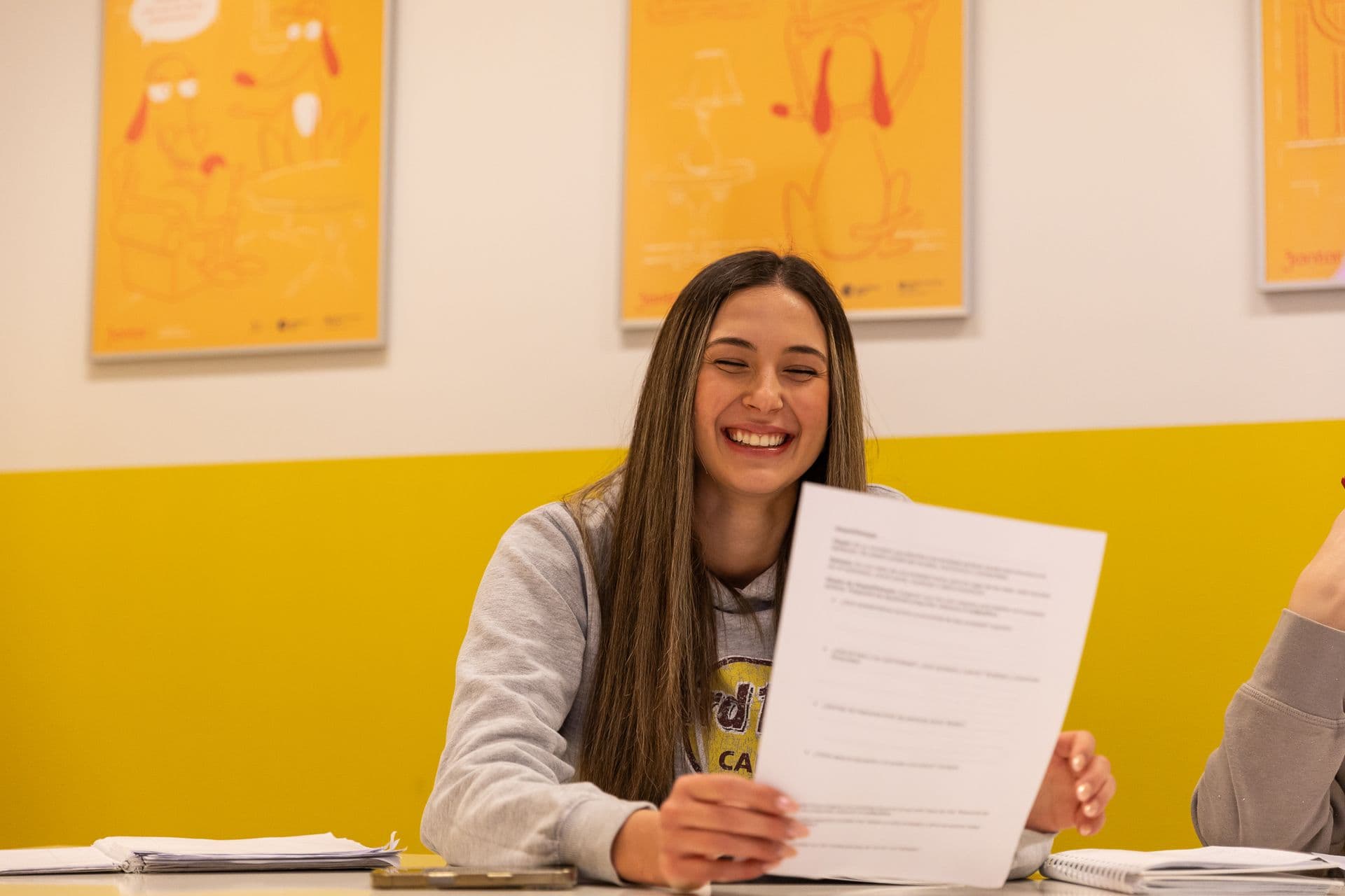 A schoolgirl holding an exam task sheet